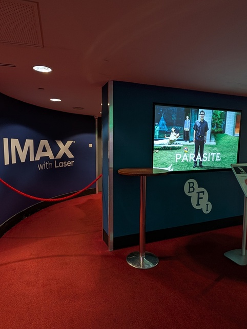 Concessions Foyer screen displaying poster for Parasite and entrance to Screen